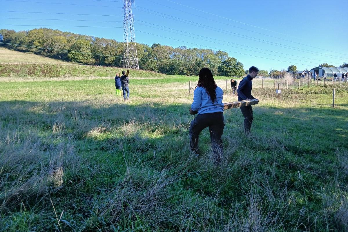 Students carrying wooden post