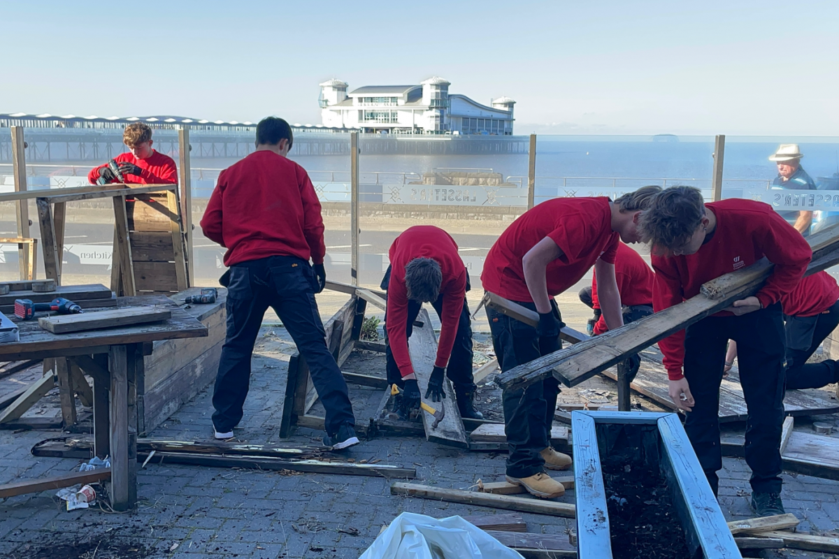 Students disassembling wooden benches