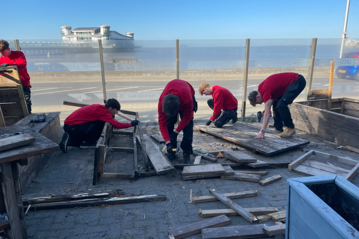 Students disassembling wooden benches