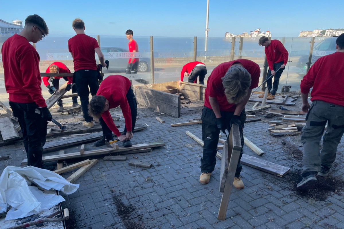 Students disassembling wooden benches 
