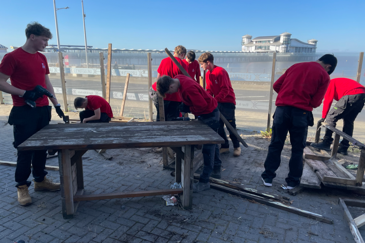 Students disassembling wooden benches 