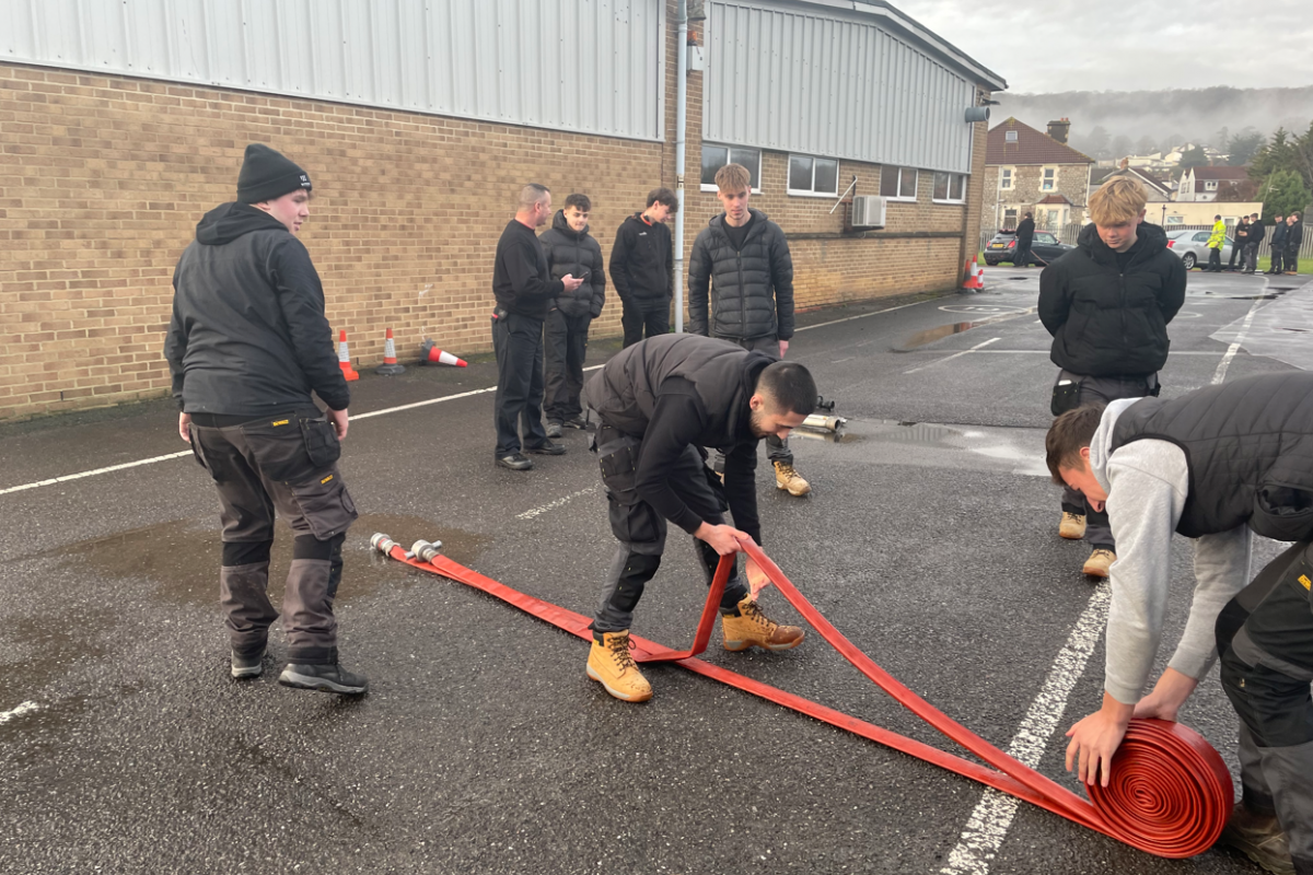 students rolling up a hose