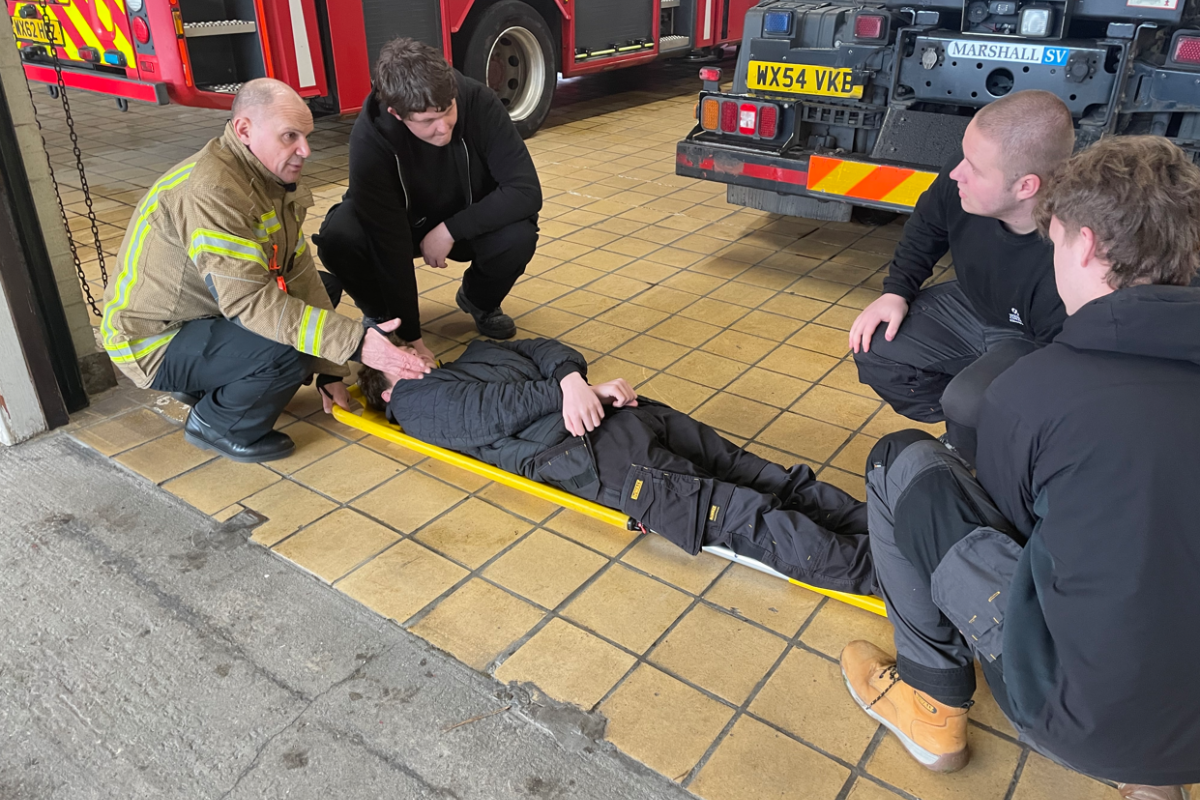 students being picked up on a stretcher 