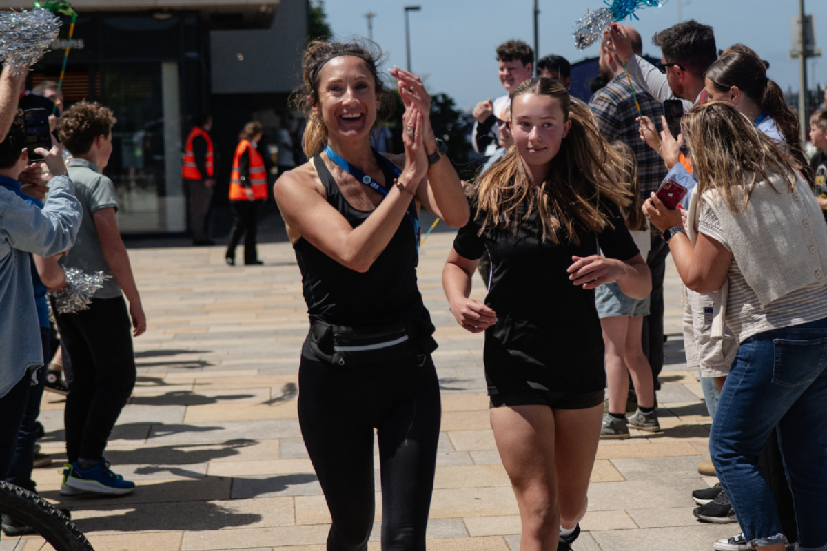 staff and learners finishing their 16 mile run and being welcomed by other attendees