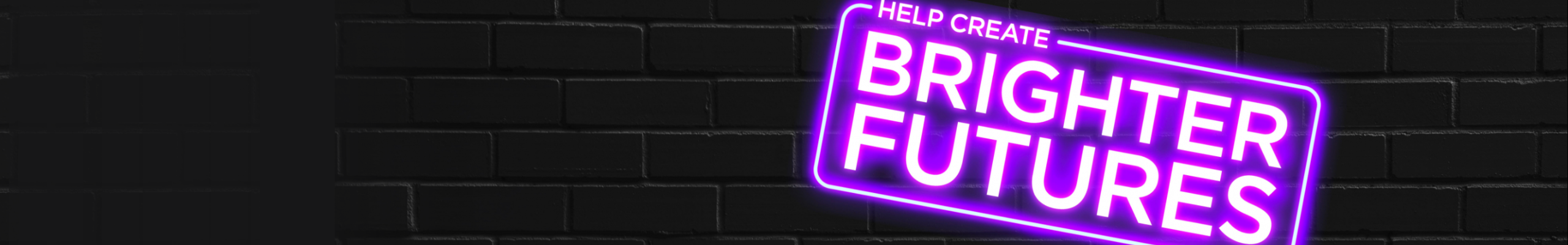 Black brick wall with neon sign reading "help create brighter futures"