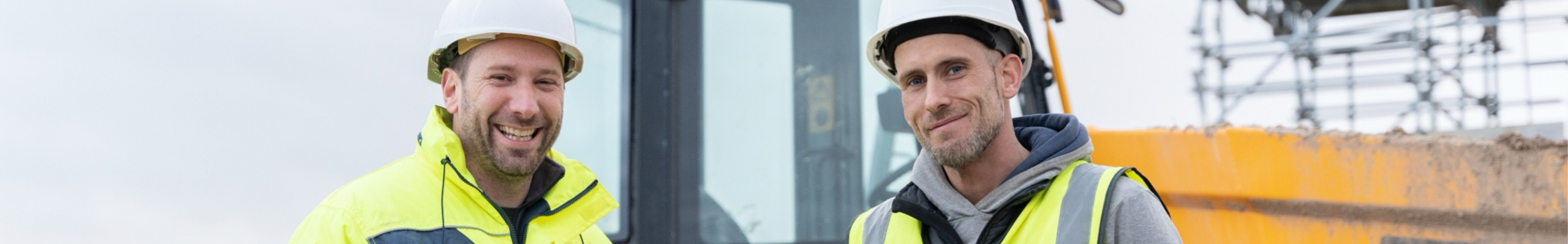 2 men in high vis standing in fornt of a JCB tractor