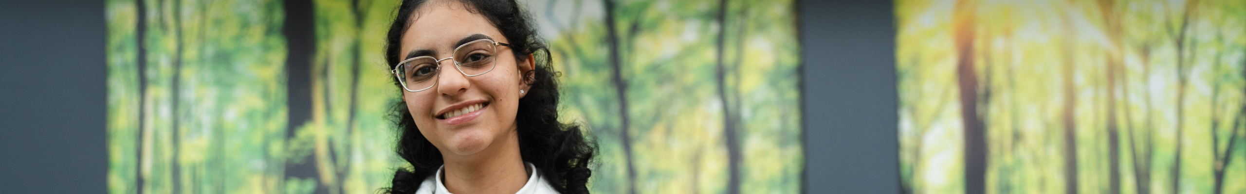 female student holding book in our LibraryPlus library