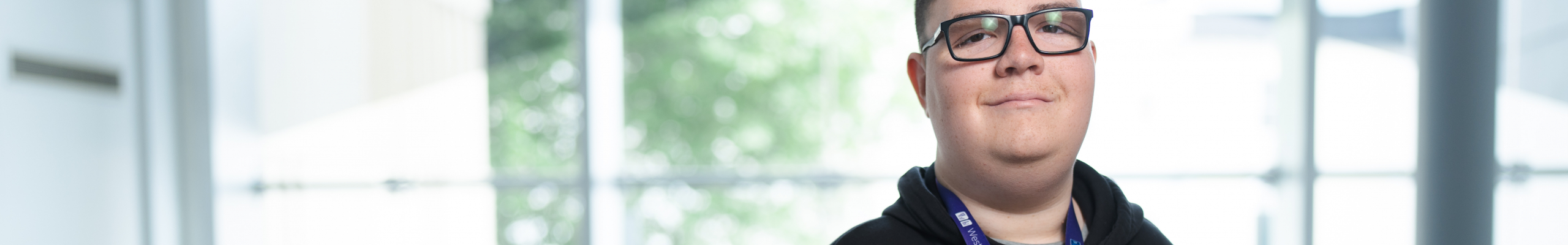 boy stood on balcony with arm rested on rail