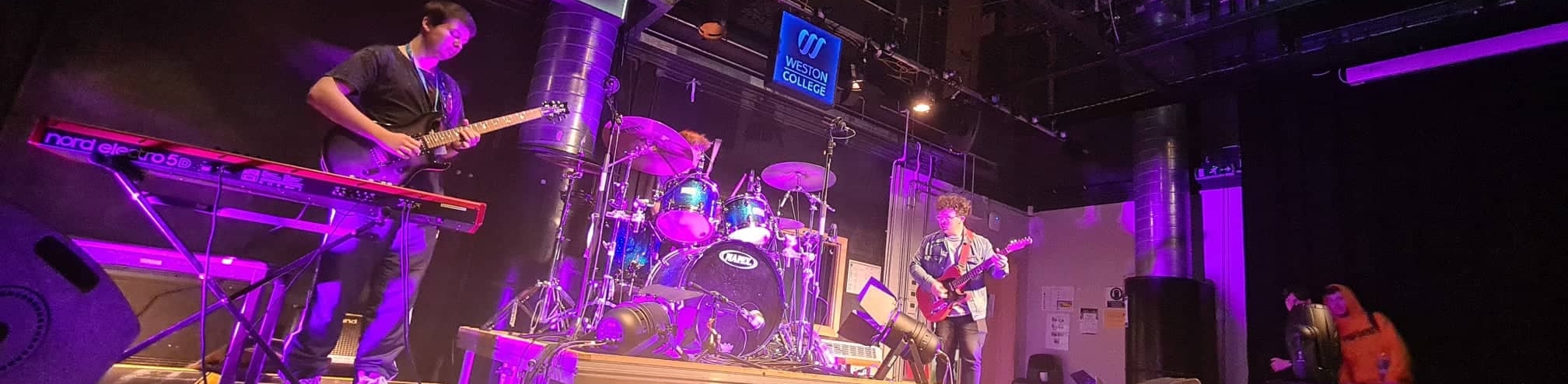 student musicians playing in a band on stage at loxton campus music department in weston super mare