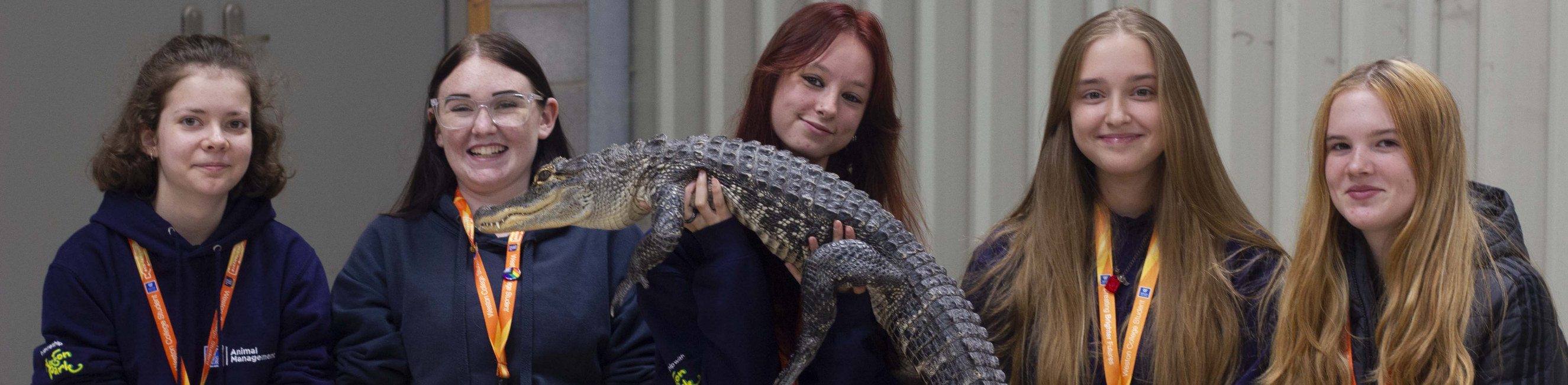 Group of learners holding alligator 