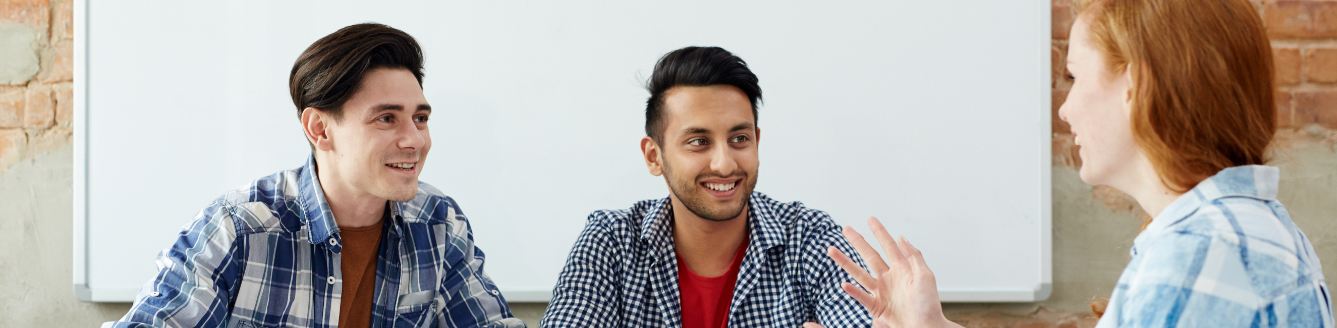 Two adult learners sat at desk and talking