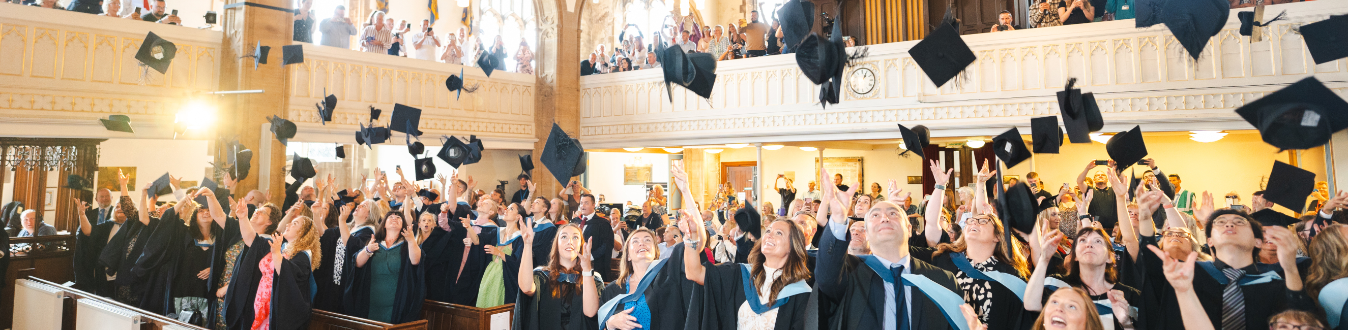 Graduating learners throwing their hats in the air
