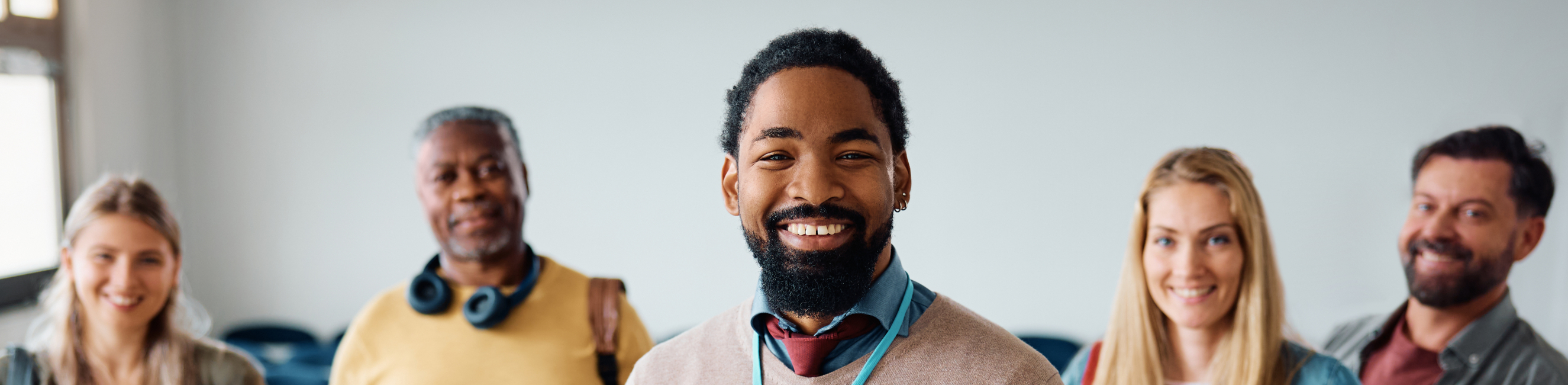 teacher with group of students in the classroom looking at camera