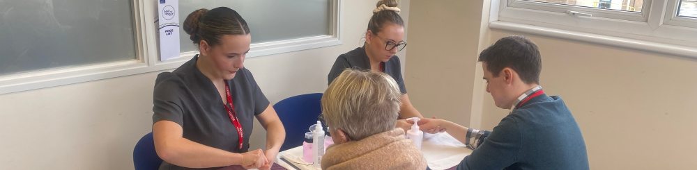 Beauty students giving hand treatments to worle school staff