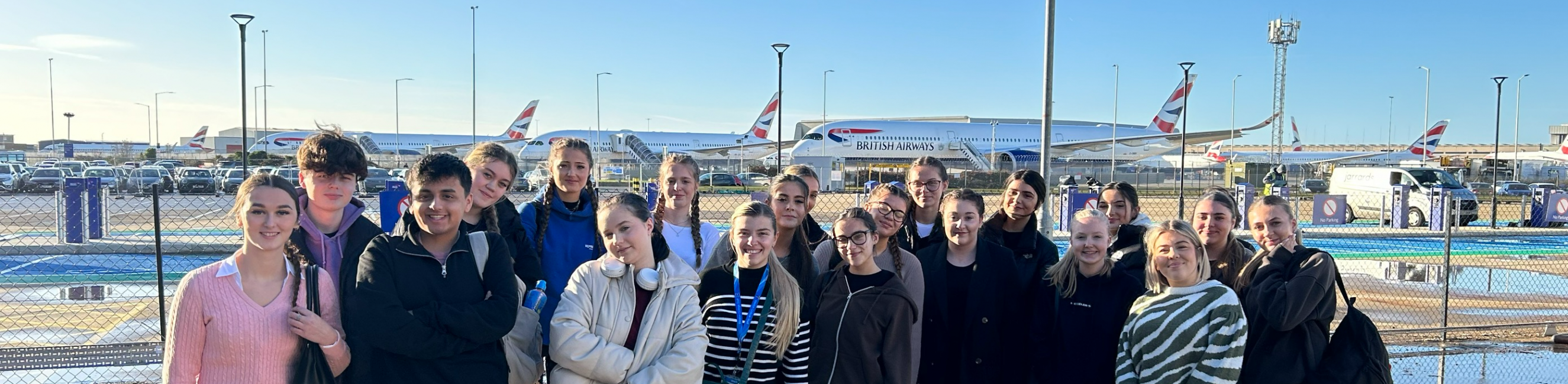 Learners in front of planes at Heathrow Airport