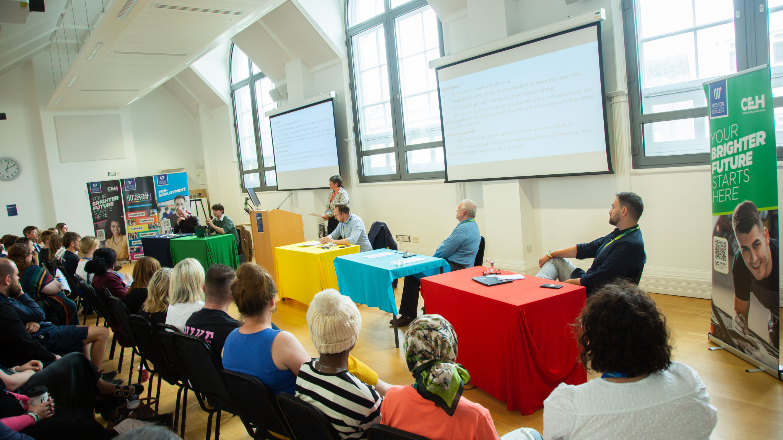 Candidates sat at the front of room answering questions