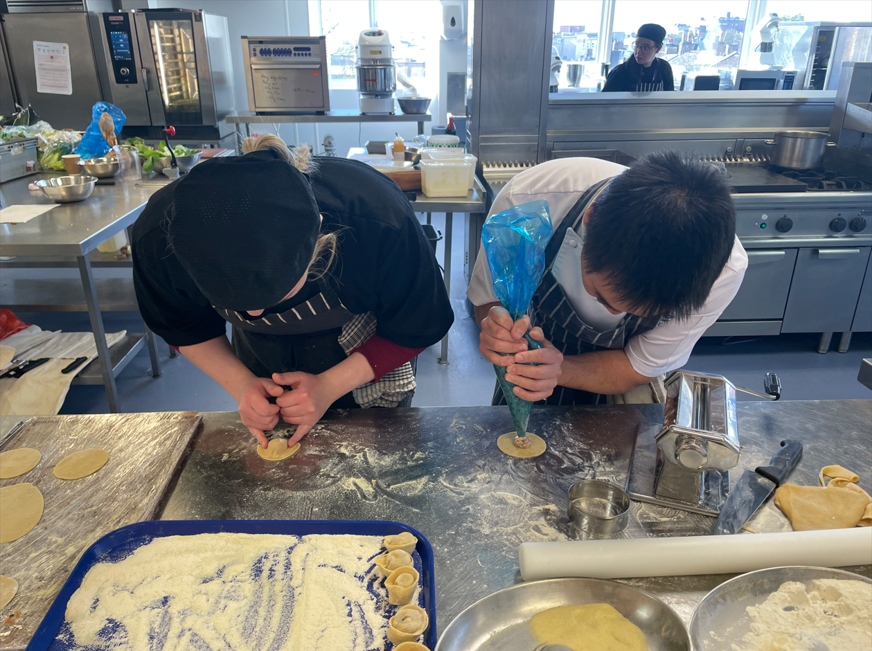 Andy and a student making dumplings