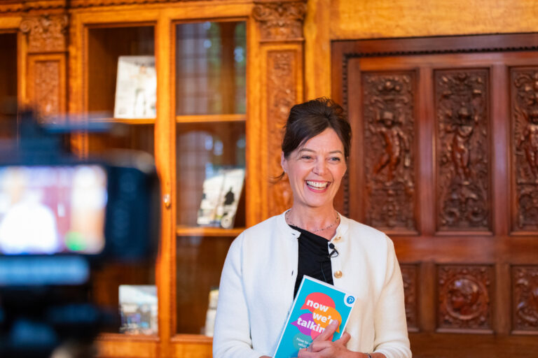 Sarah Rozenthuler holding a book and smiling