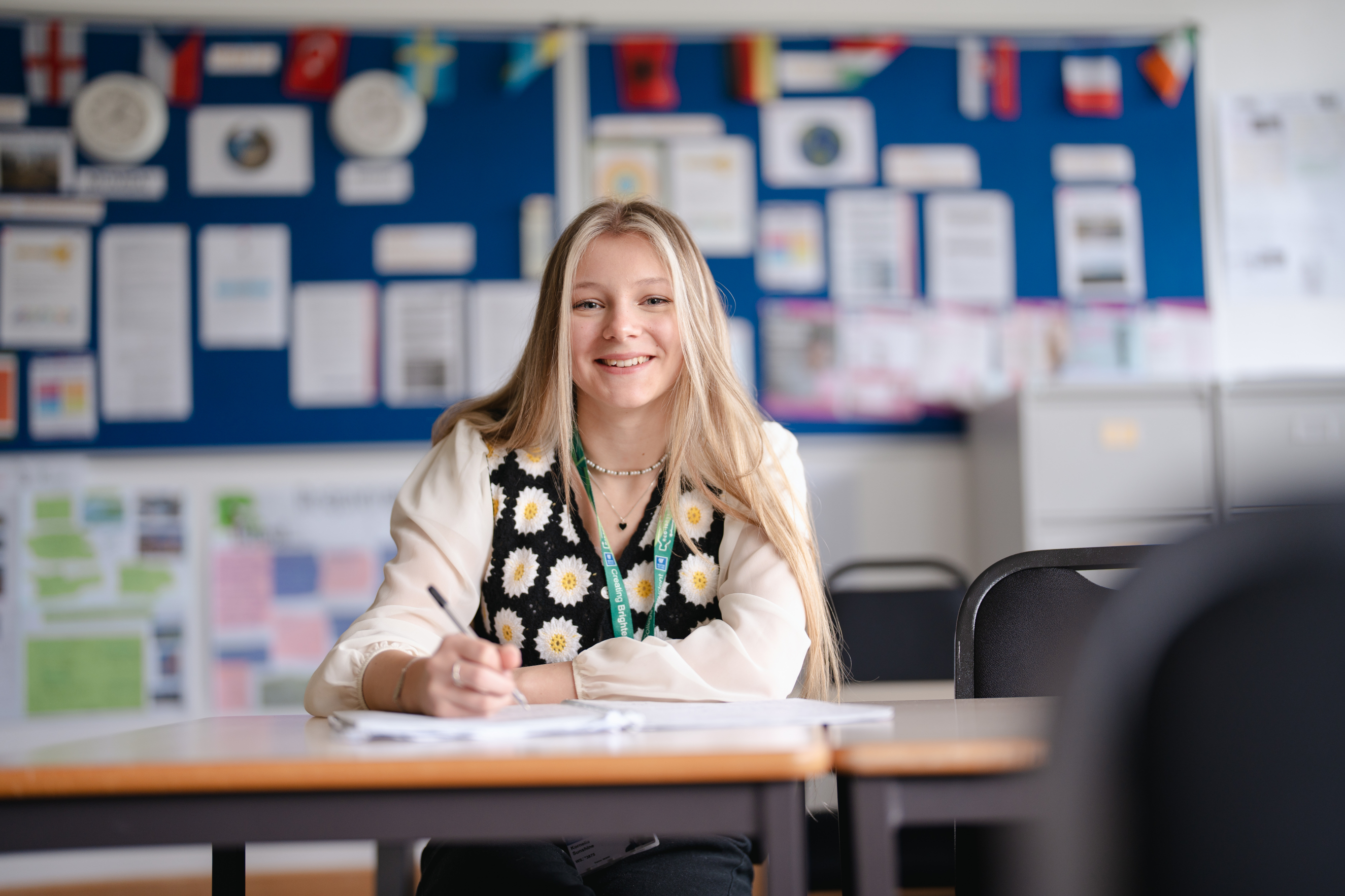 a levels student writing in a book while sat at a desk
