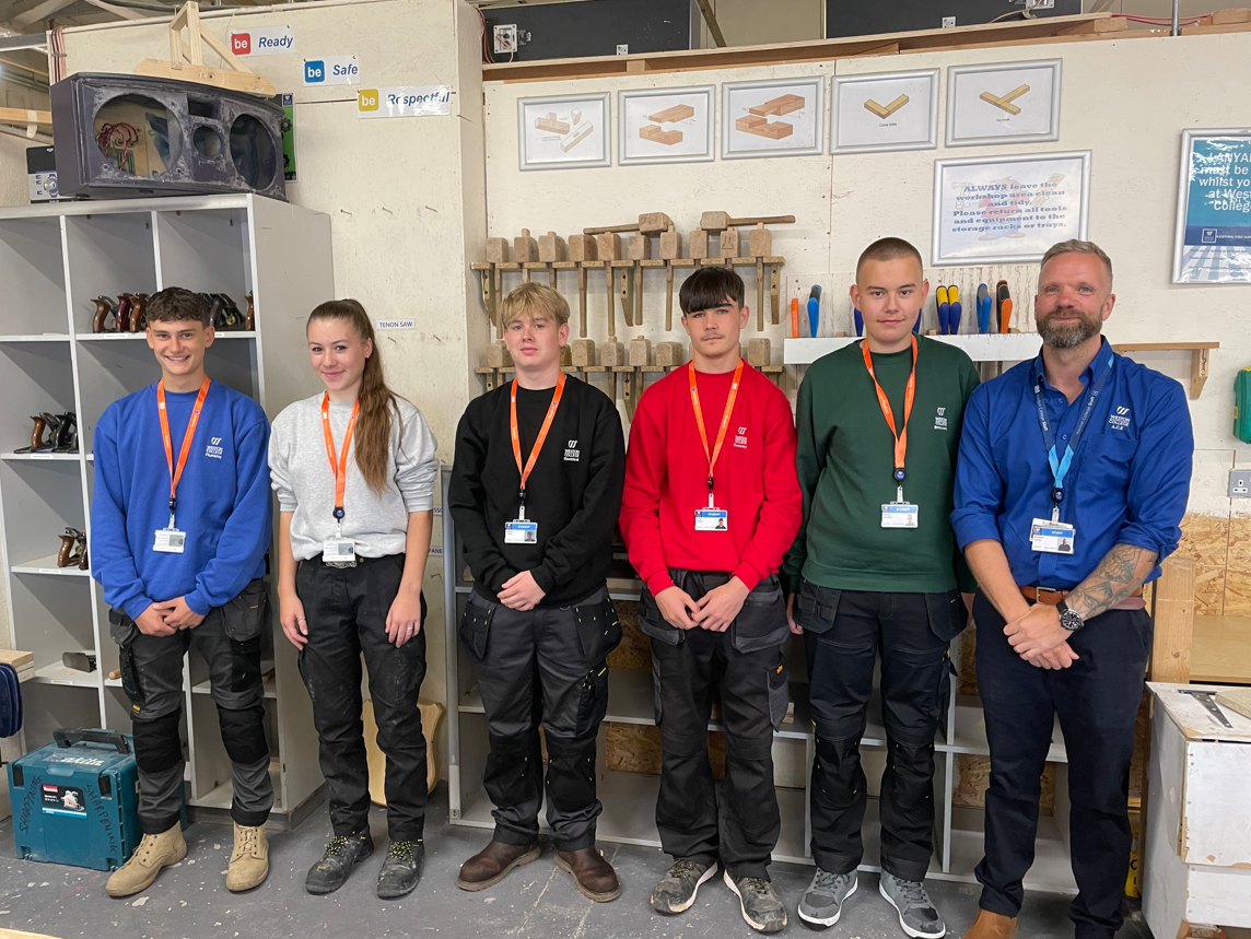 Construction learners from each trade standing smiling in their new uniform