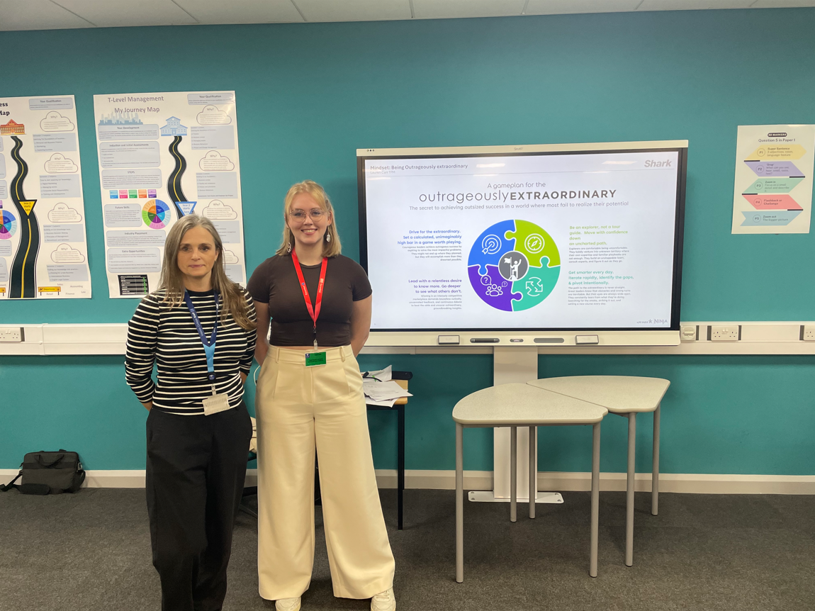Lauren and Business lecturer, Emma, standing next to the SharkNinja 'outrageously extraordinary' presentation