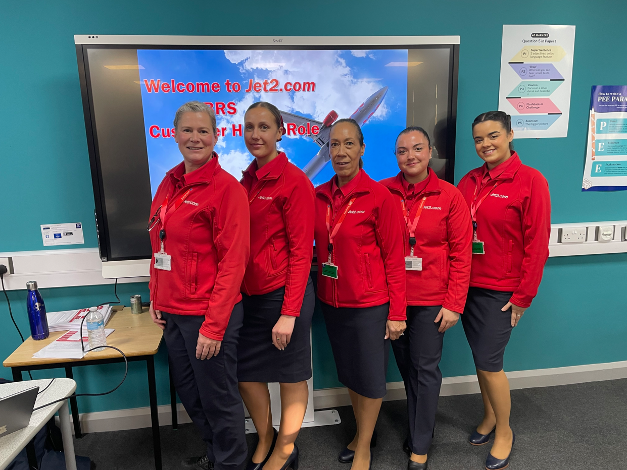 Jet2 staff standing in the Travel classroom in front of their presentation