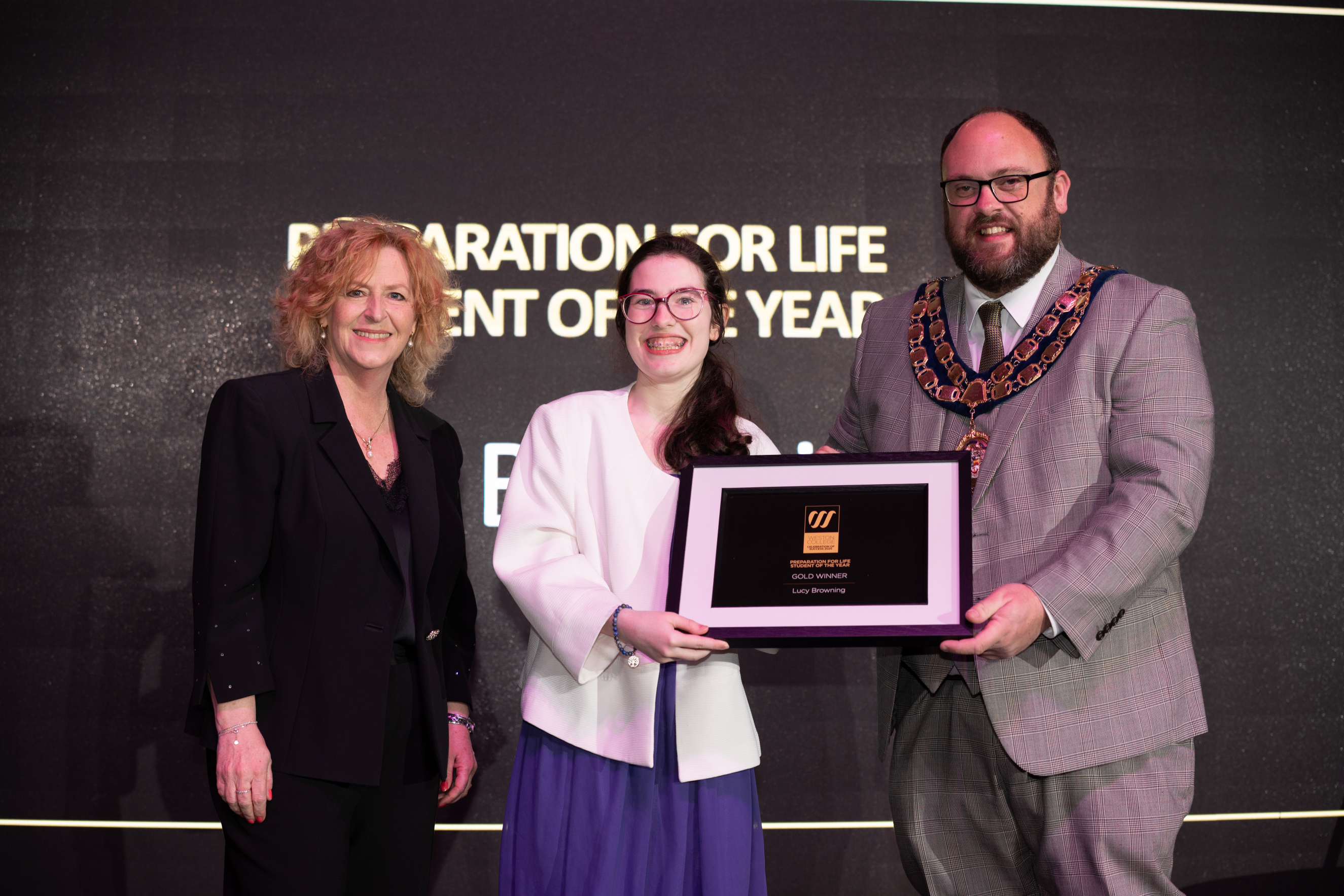 Lucy collecting her award from Principal Pat Jones and the Mayor