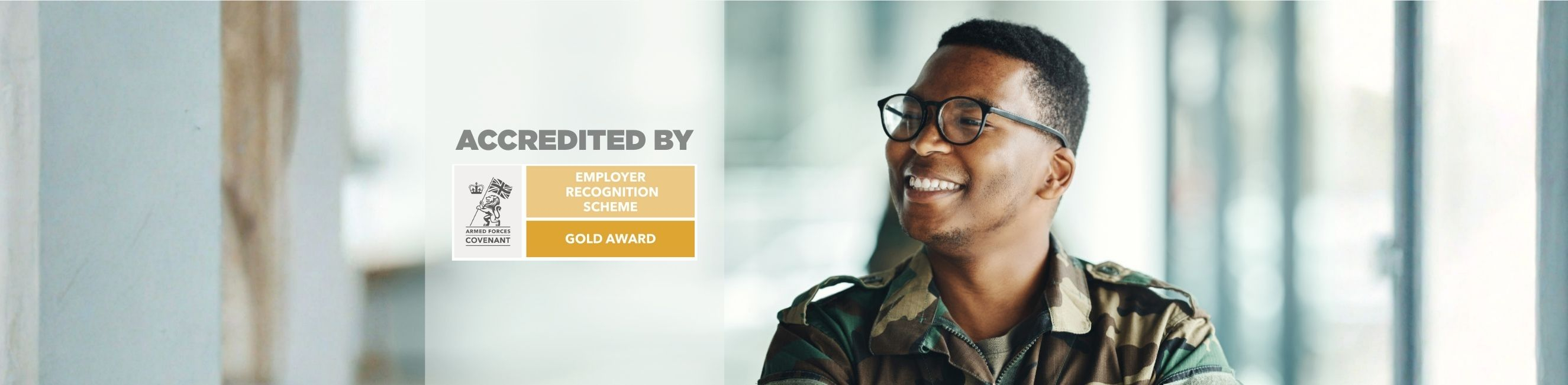 Veteran smiling and a logo of accreditation - Armed forces covent gold award