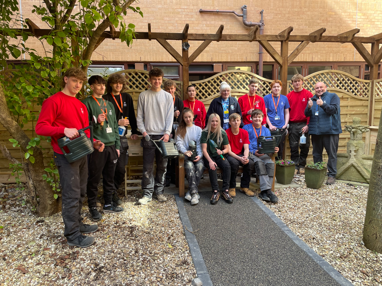 Construction students smiling in the Sanctuary Garden at Weston Hospital