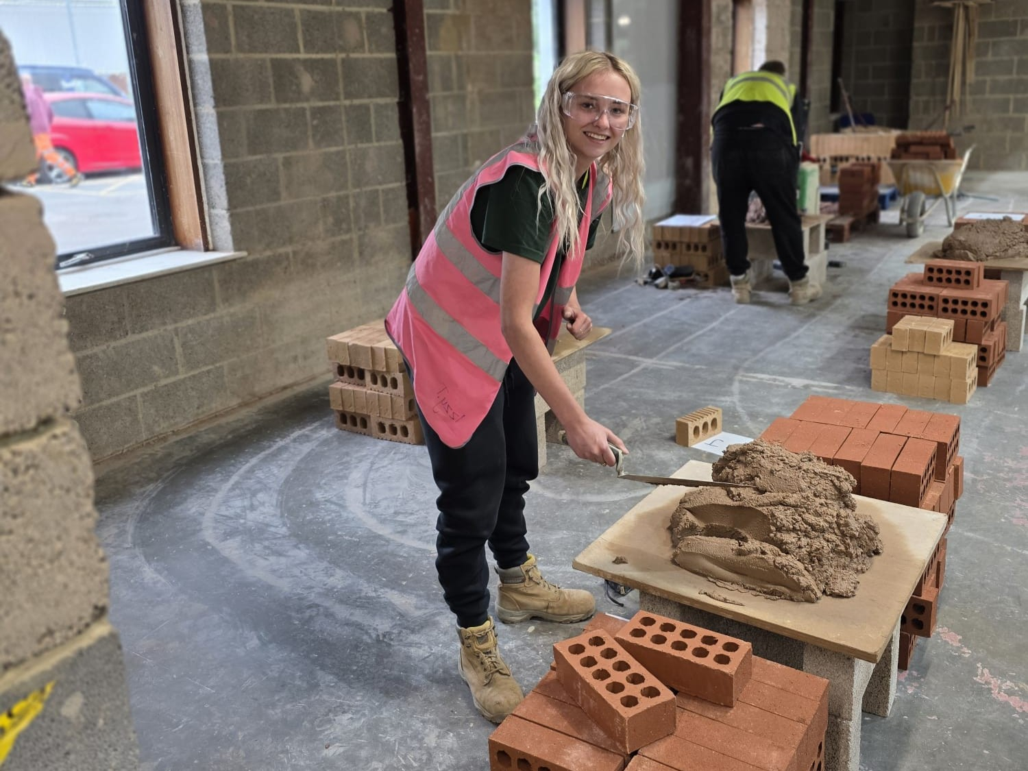 Izzy bricklaying her wall