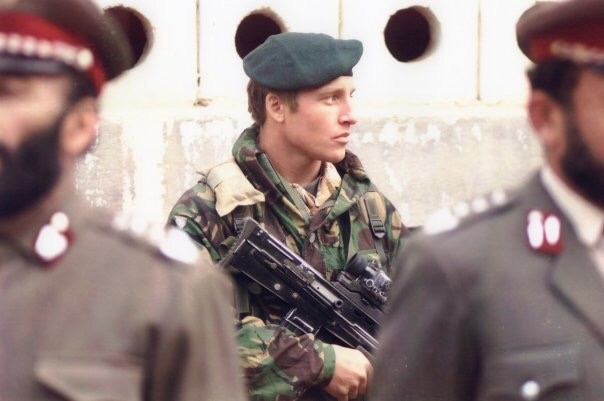 A picture of Darran when he was a Royal Marines Commando. He is dressed in his soldier's uniform and is carrying a gun. 