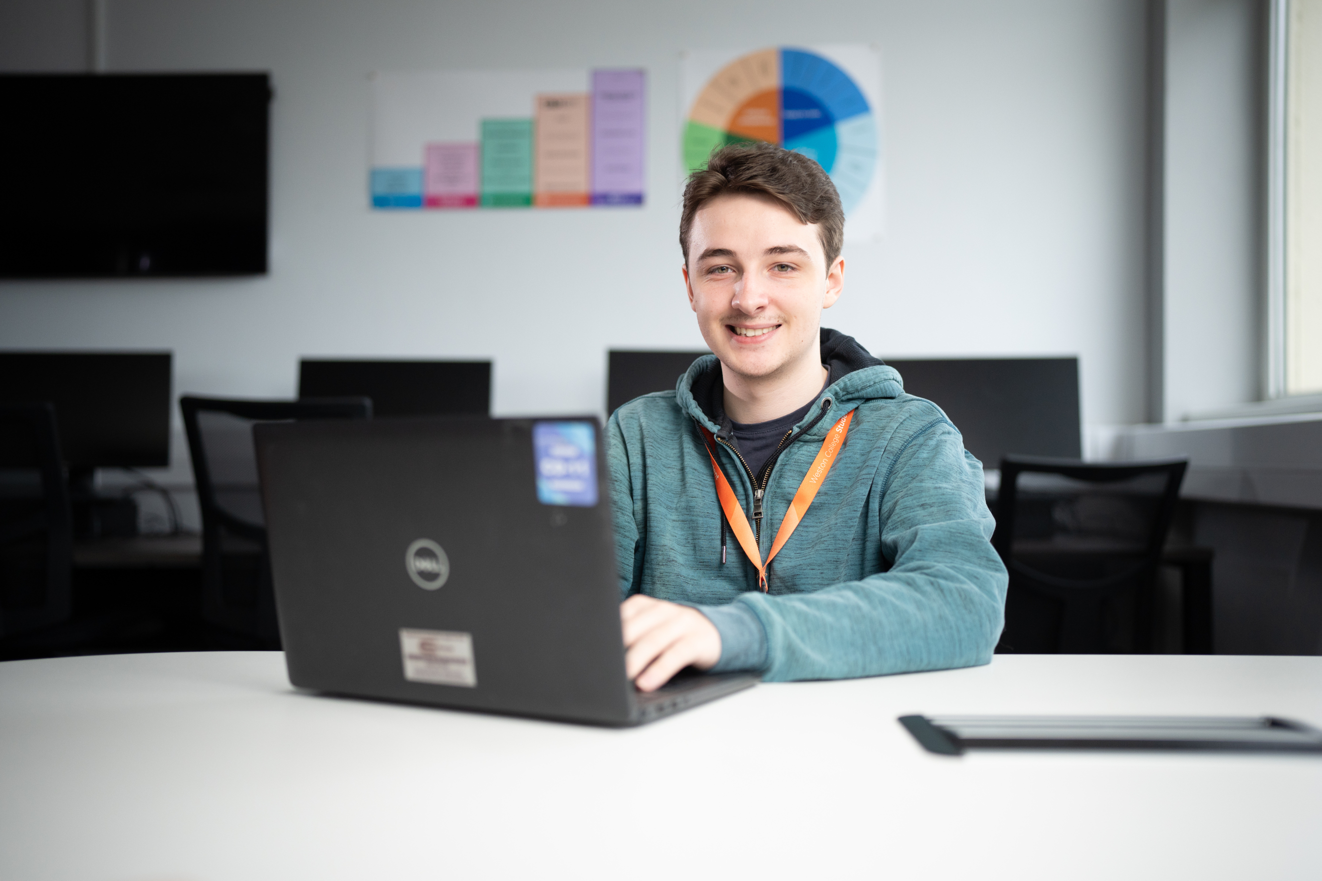 Student sat at desk working on his laptop