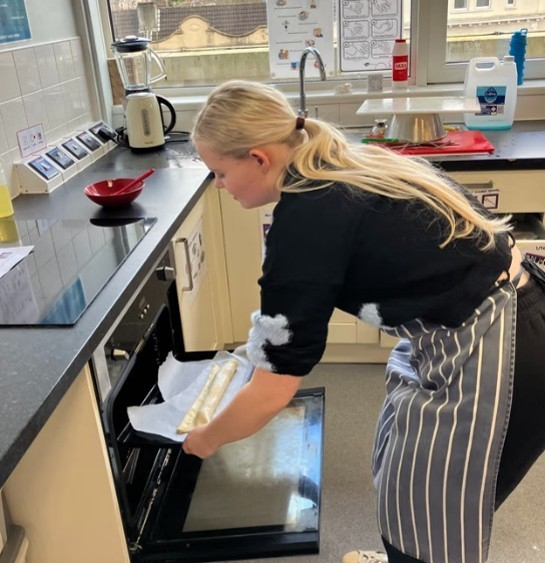 Student putting something in the oven at her work experience placement