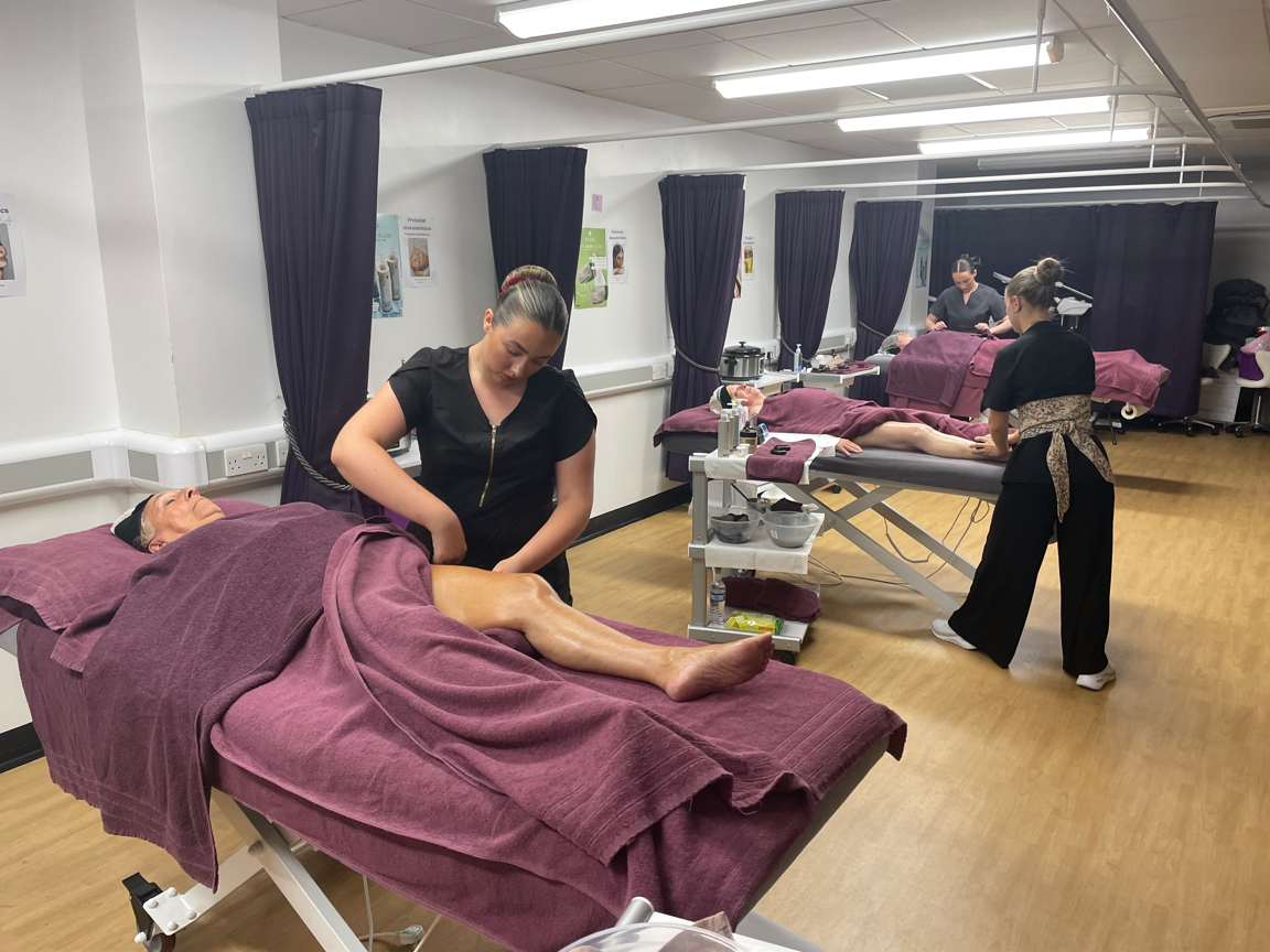 Competitors completing hot stone massages on clients