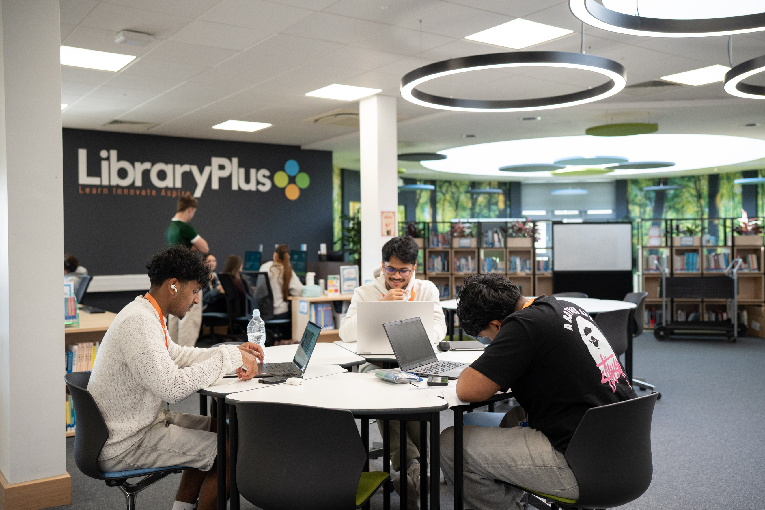 Learners studying in the library on their laptops