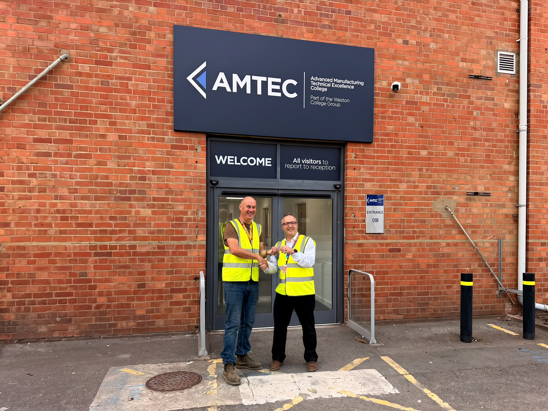 Mark and Andy Shaking Hands in front of AMTEC Building