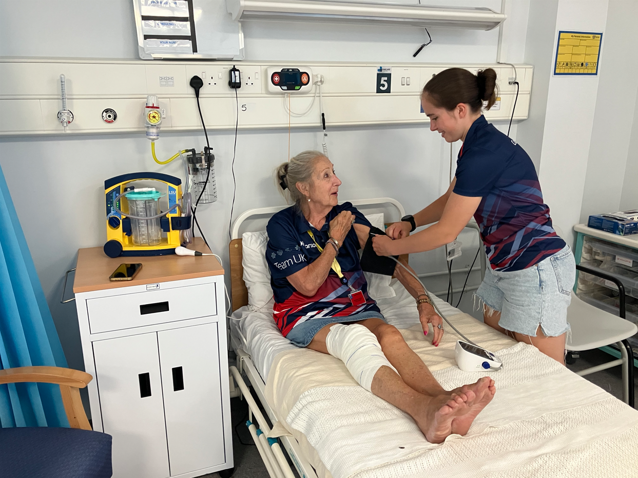 Competitor checking the blood pressure of Team UK staff member