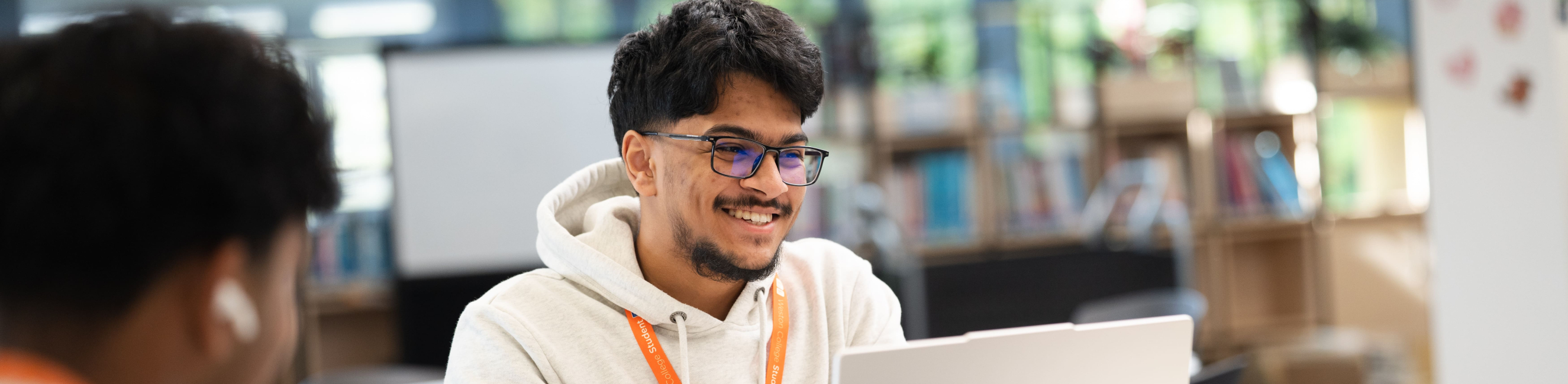 student smiling at a laptop