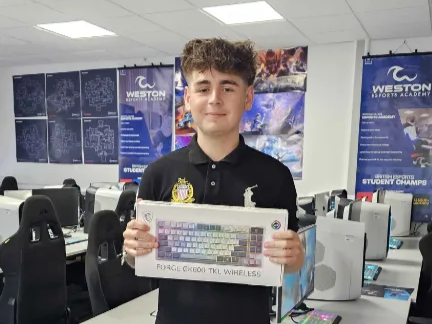 Student smiling and holding the MSI Keyboard he won