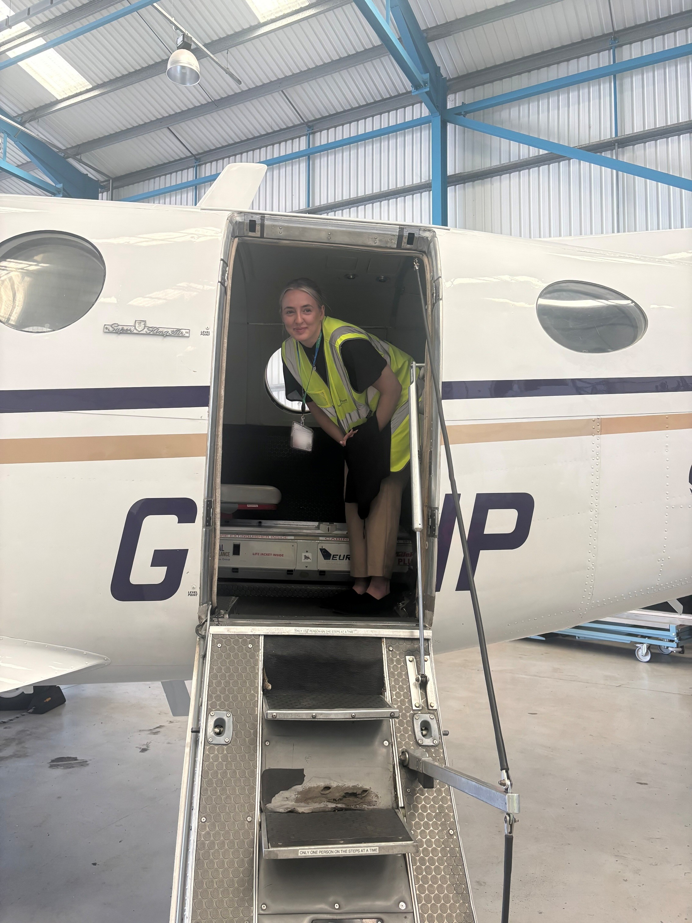 Sophie stood inside a plane smiling