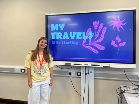 Ellie smiling next to the powerpoint presentation she made
