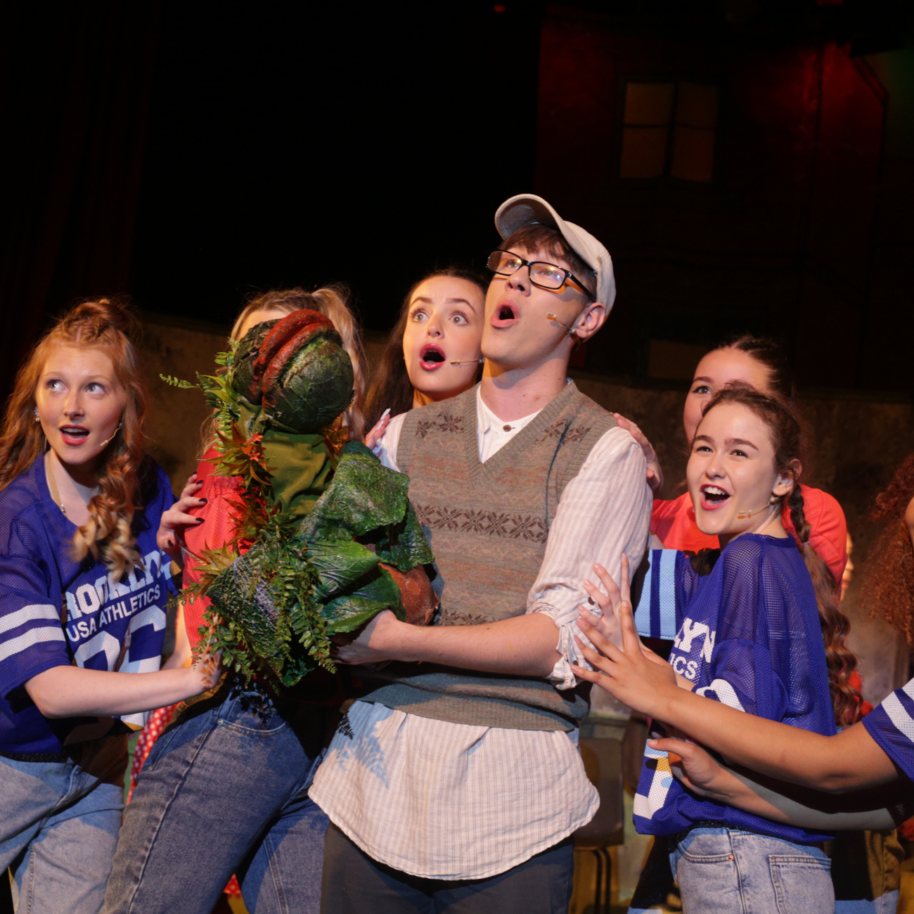performing arts students on stage singing little shop of horrors