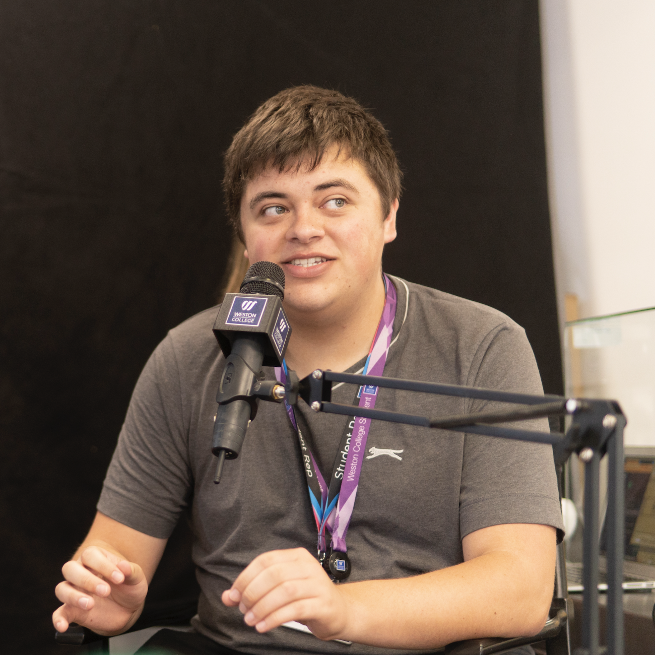 Male student radio host talking into microphone
