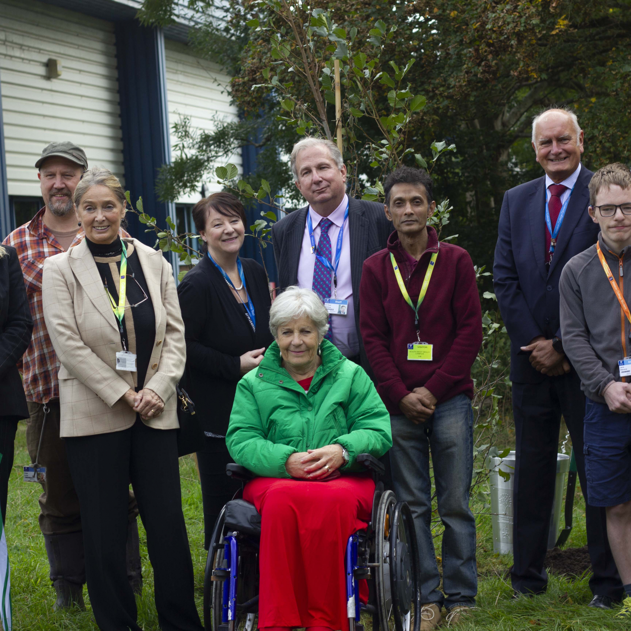 Sir Paul Phillips and the Lord Lieutenant posing in front of Tree of Trees with students and guests of honour