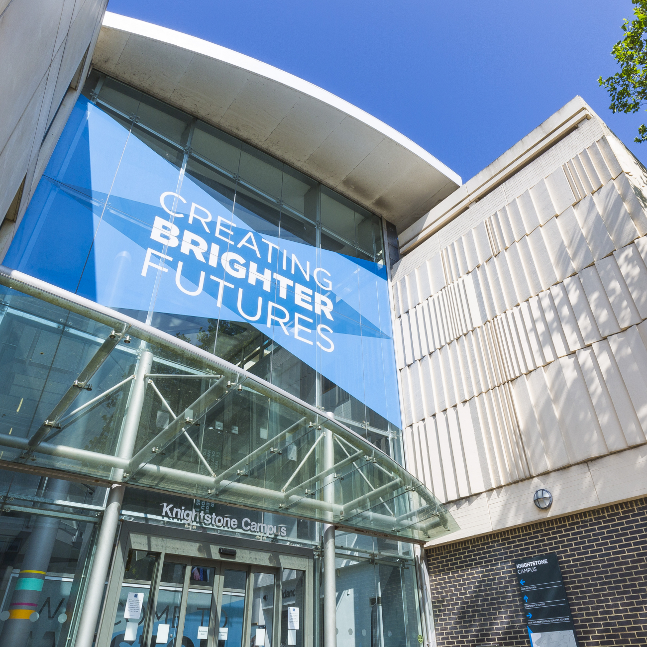 Outside Weston College Knightstone Campus with sign that says "Creating Brighter Futures"