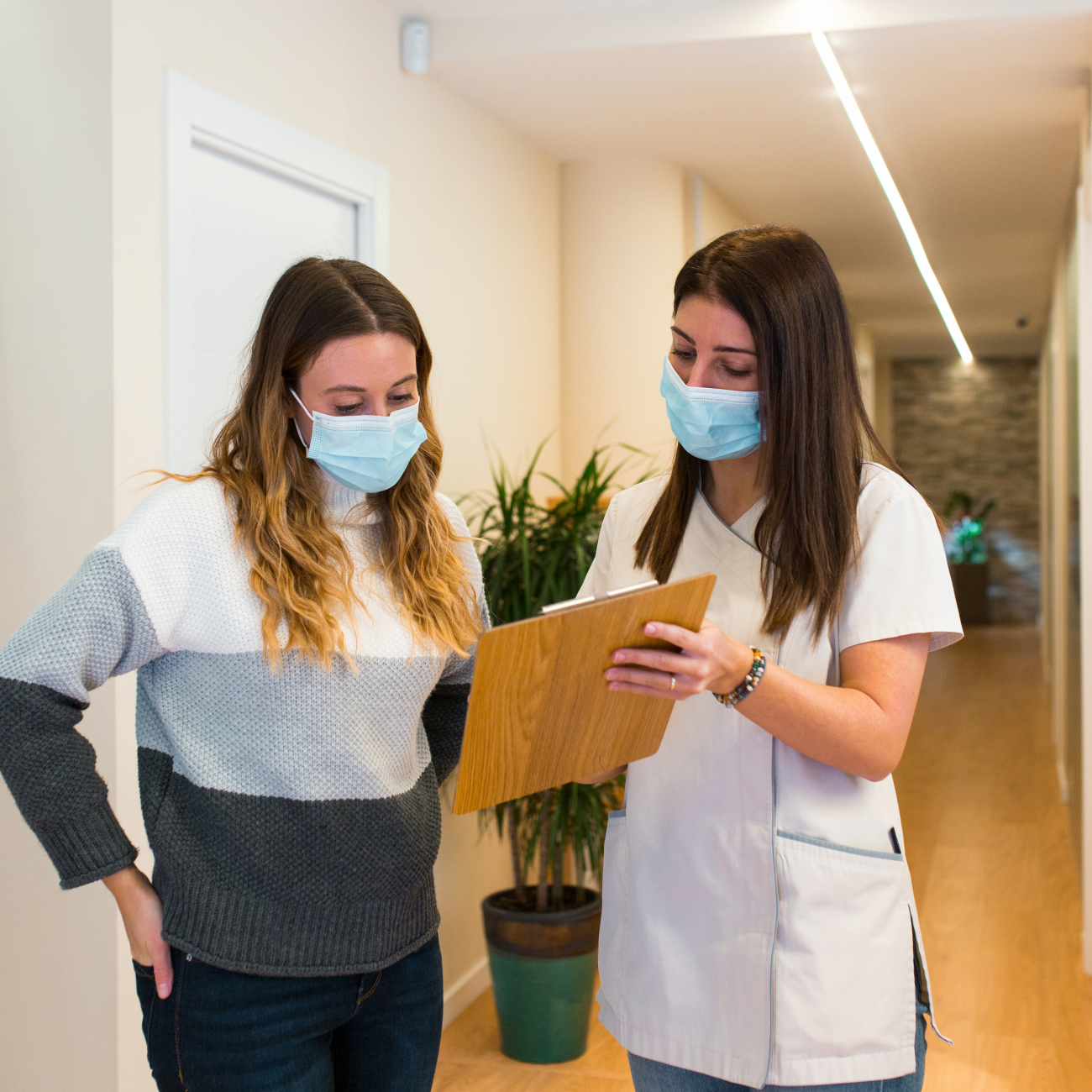 Two females working in a doctor surgery looking at a clipboard