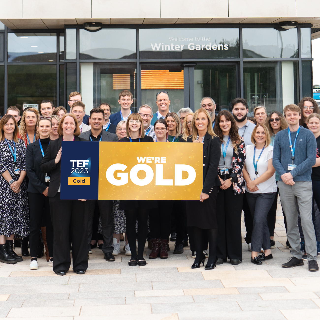 UCW staff holding a TEF Gold banner outside the Winter Gardens