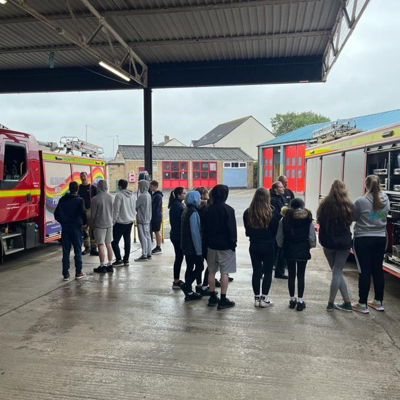 Learners listening to a talk stood by fire engines