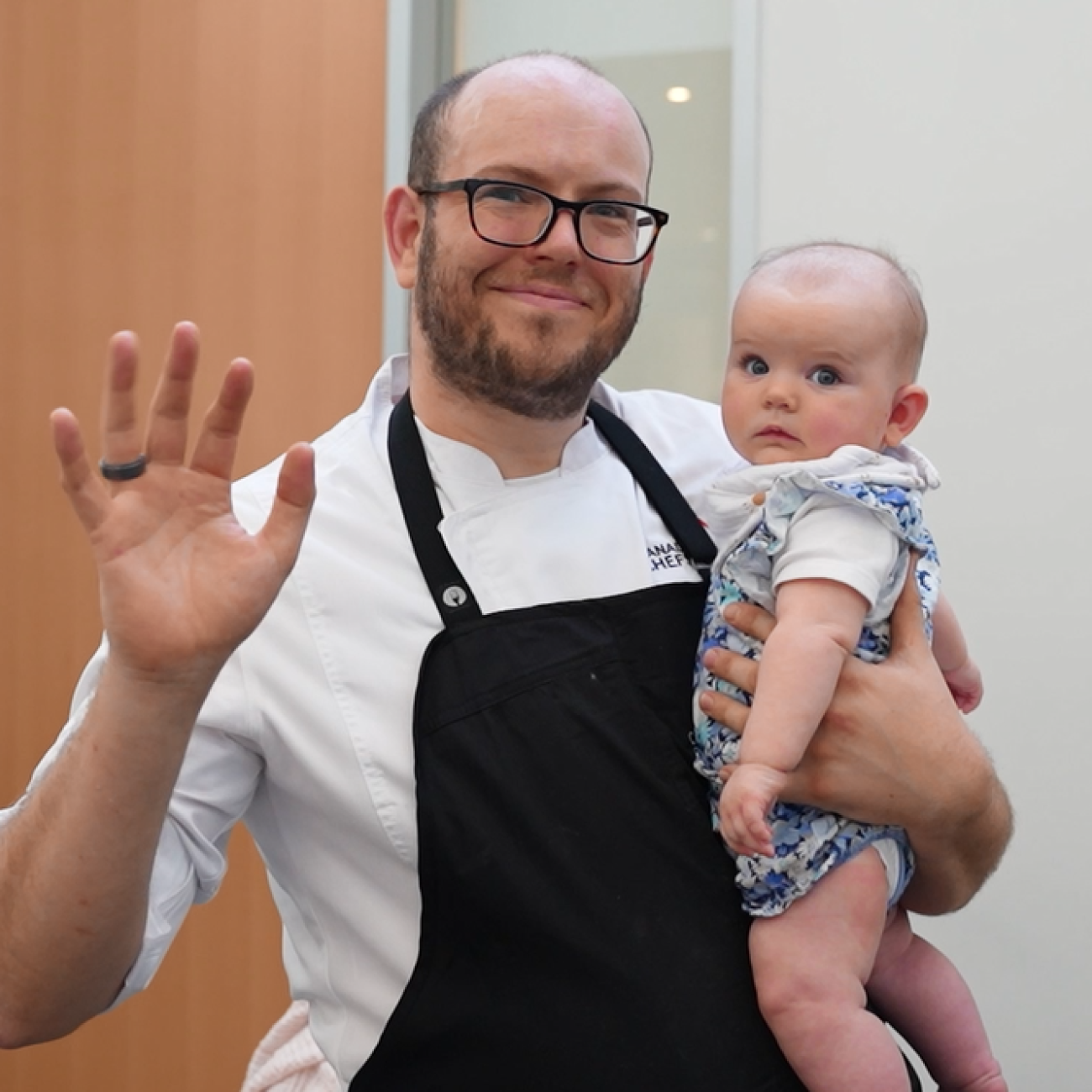 Rich Perks holding his child waving