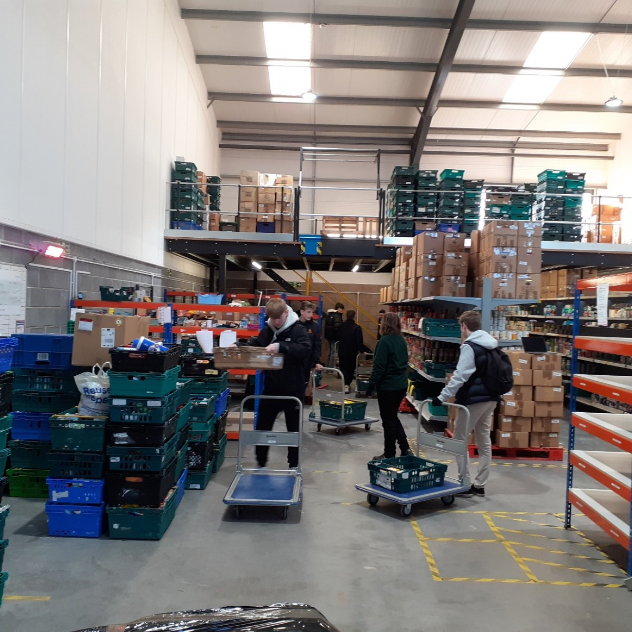 Learners stocking food onto trolleys in a warehouse